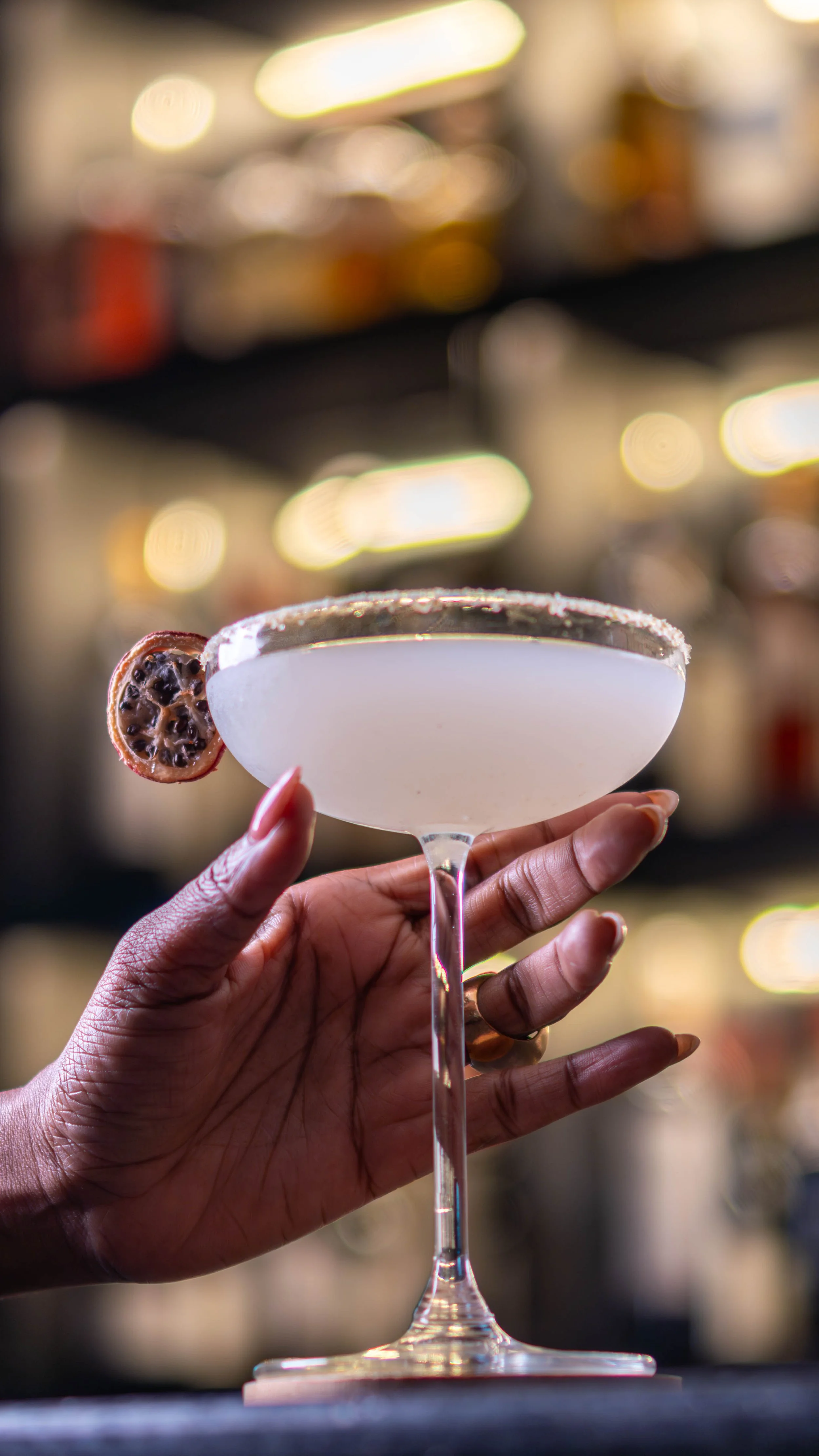 Mão a segurar um cocktail servido no bar do Restaurante Kissanje